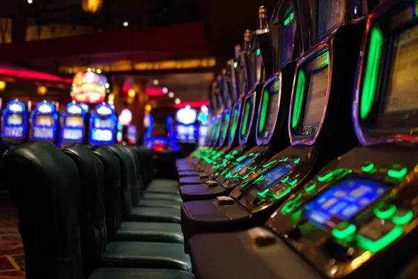 A woman in a luxurious green gown next to an ornate roulette wheel, capturing the upscale casino mood of 7U77.