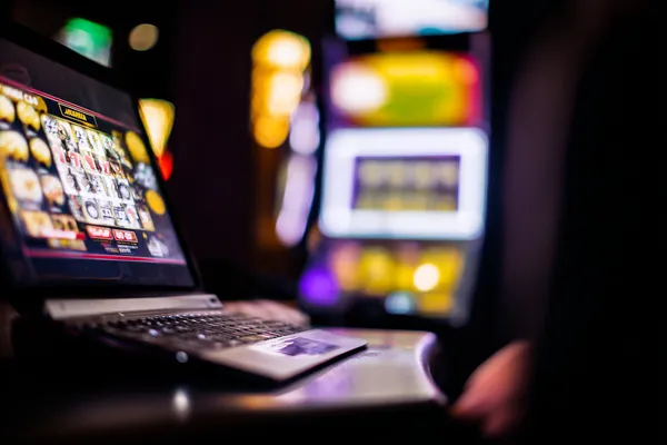 A woman smiling by bright slot machines showing lucky symbols, showcasing the exciting slot offerings at 7U77.